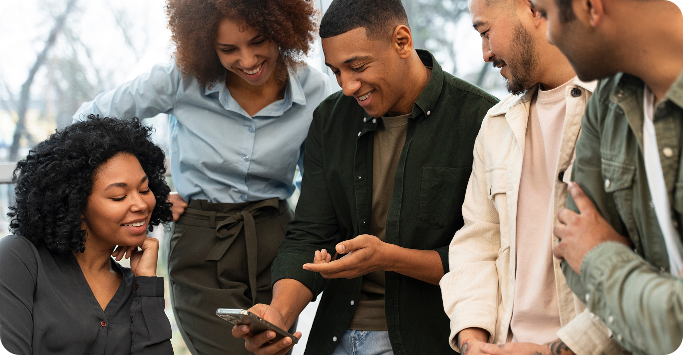 A team gathering around a phone, exploring Ruach's communication platform